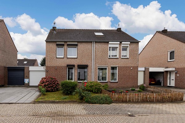 Ruime en praktisch ingedeelde geschakelde twee-onder-een-kapwoning met vier slaapkamers, aanbouw, garage, eigen oprit en een zonnige tuin.