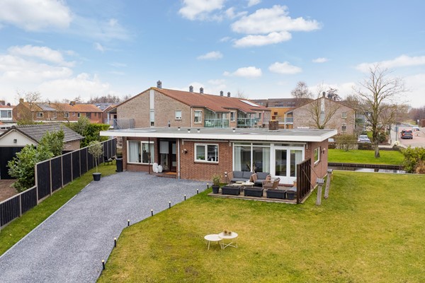 Te koop: Op een prominente locatie midden in het dorp staat deze vrijstaande bungalow uit de jaren ’60, gelegen op een royale kavel van maar liefst 677 m². 